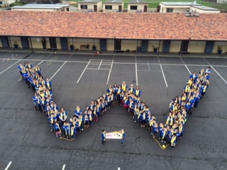 A large group of students standing in formation to make a 